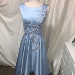 This is a satin dress with a corset bask and a flower detail on the front.